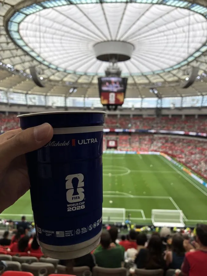 Holding a World Cup 2026 cup above the soccer field at BC Place
